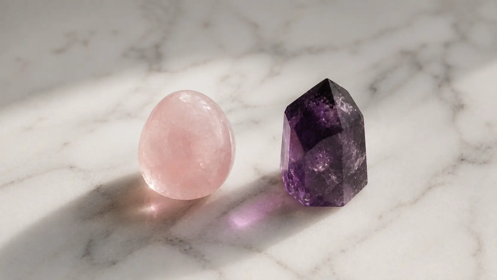 Astrology love destiny birth chart — rose quartz and amethyst crystals placed side by side on white marble surface, soft natural light