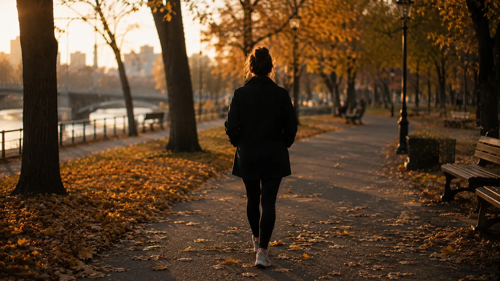Astrology relationship advice — woman walking alone through an autumn urban park, hands in pockets, shot from behind