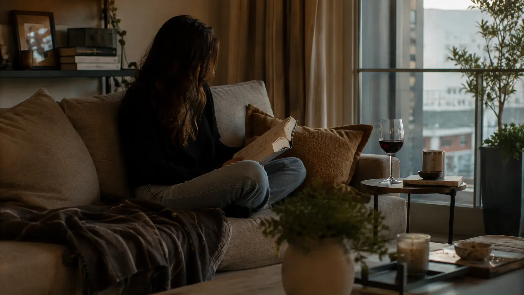 Gemini man pull away psychology — woman reading alone at home, completely absorbed in her own world, not waiting by her phone