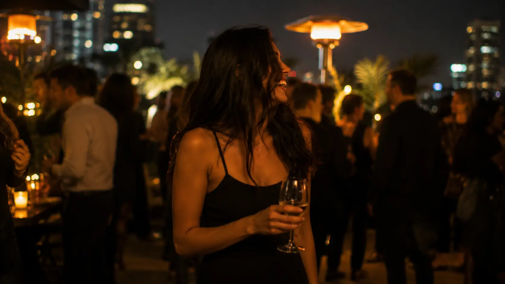 Make Gemini man think about you — woman laughing genuinely at a social gathering, fully present and magnetic, not waiting for anyone