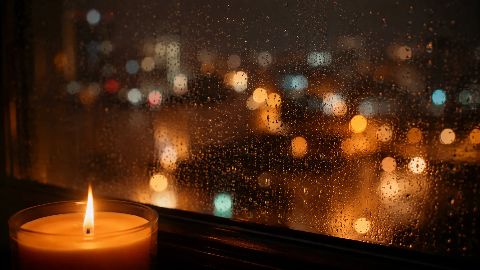 Venus sign physical attraction soulmate — candle flame in focus against blurred city lights at night through a rainy window